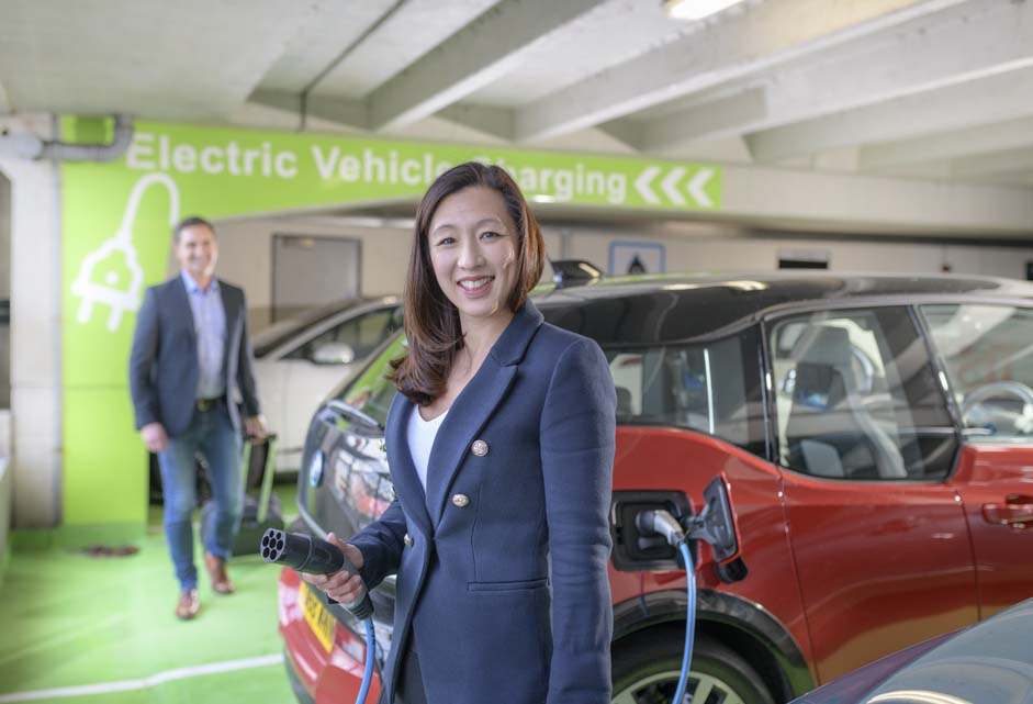 Electric vehicle - woman charging car