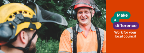 Council worker in hard hat smiling at colleague