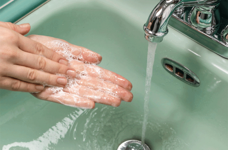 Person washing hands in the sink