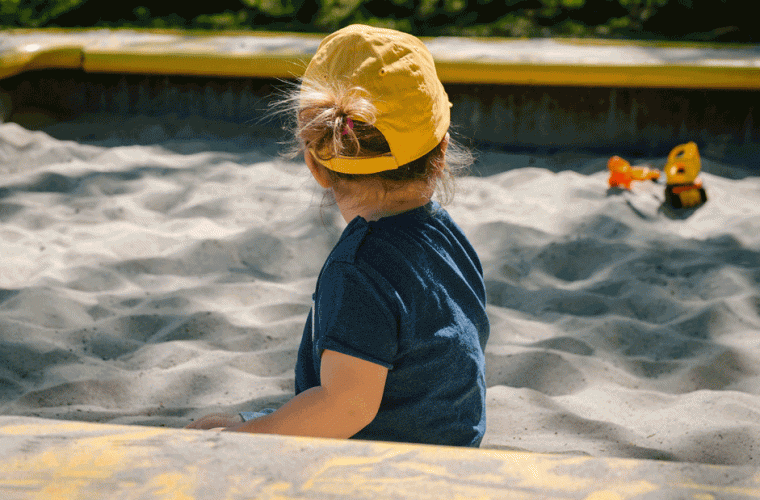 Toddler playing in sandbox