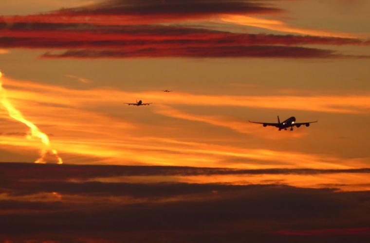 Two planes flying through the sunset over Heathrow 