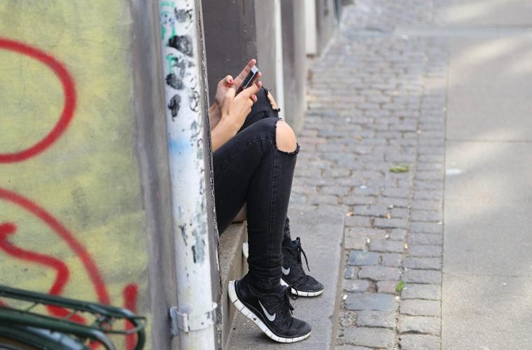 Teen sitting on phone