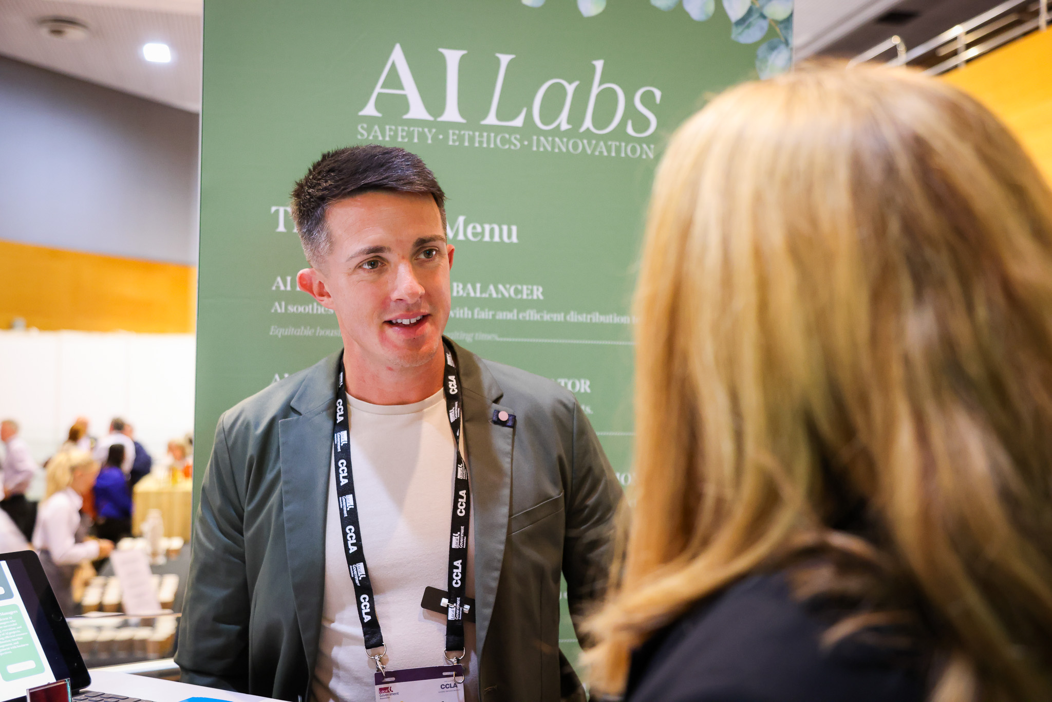 Lewis Sheldrake talking to a delegate at a conference stand