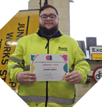 A Caucasian male in a high vis jacket holding a apprentice of the year certificate