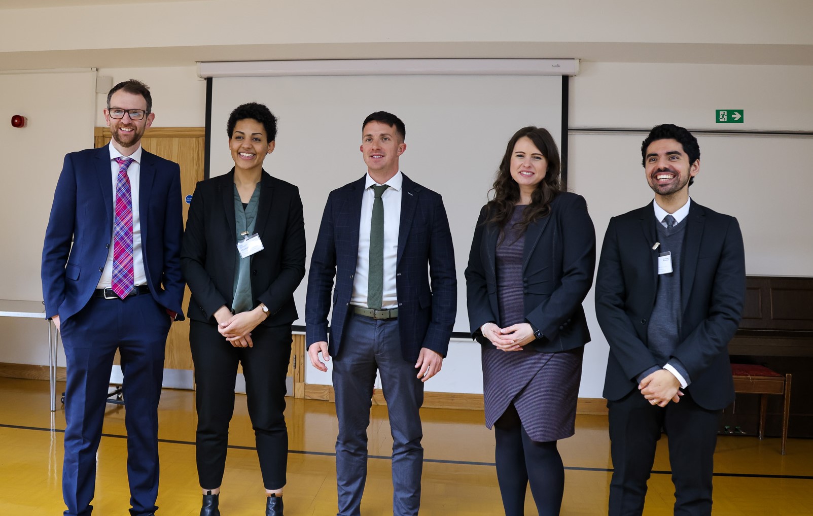 The five members of Team Catalyst standing in a row, dressed formally.