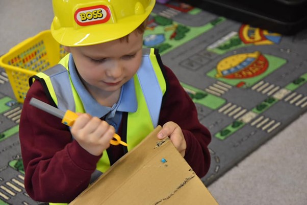 A young STEM Club participant trying a cardboard engineering challenge