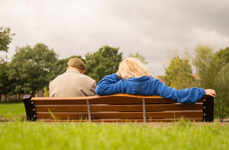 A couple sitting on a park bench