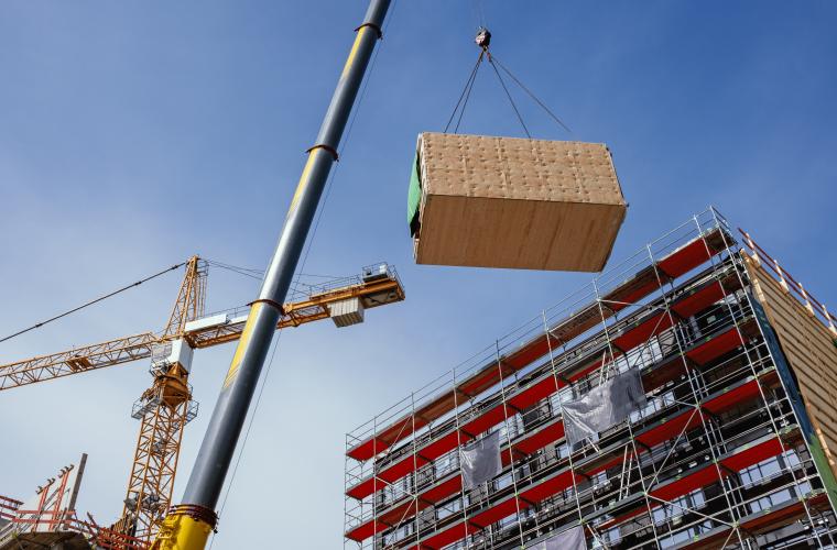 Crane delivers container of goods onto construction site