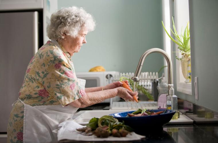 Elderly woman preparing food