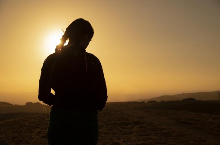 Silhouette of a young girl at sunset