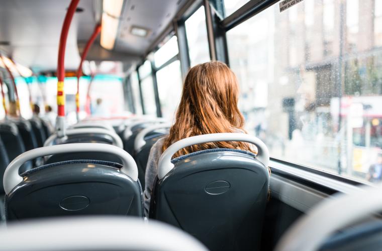 Rear view of a woman sitting on a bus looking out of the window