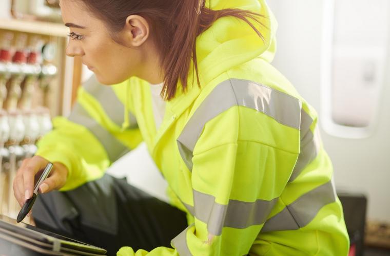 women working on technical equipment in high vis jacket