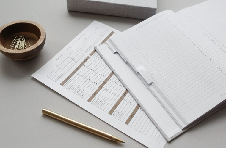 A finance tracker notebook with pen 