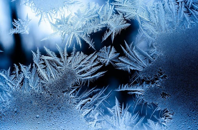 Frost on glass against a dark blue background
