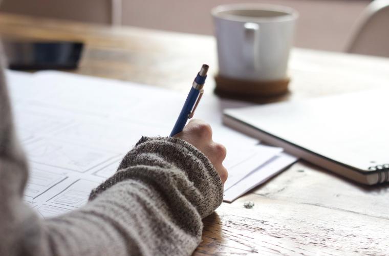 Young person writing at a desk