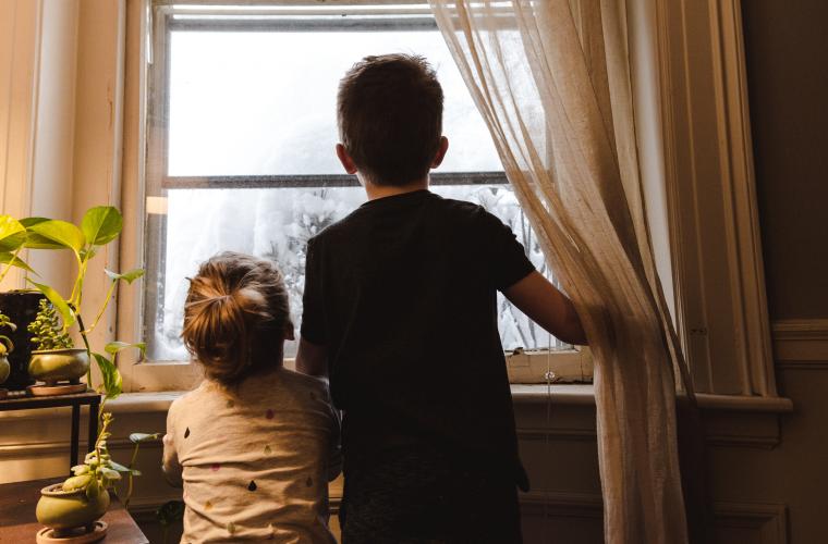 Boy and girl looking out of window