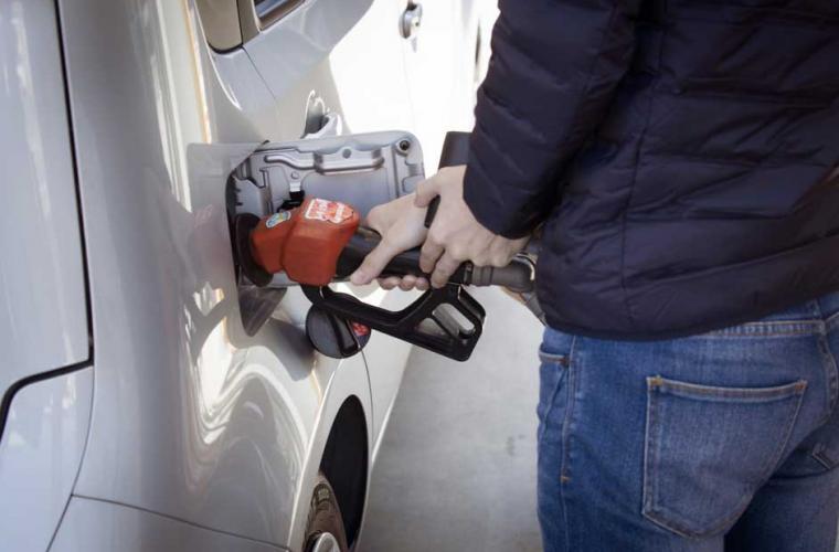 man's hands on petrol nozzle putting petrol into a car