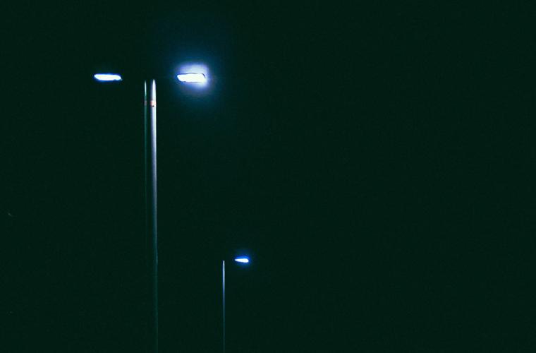 Street lights against a pitch black sky