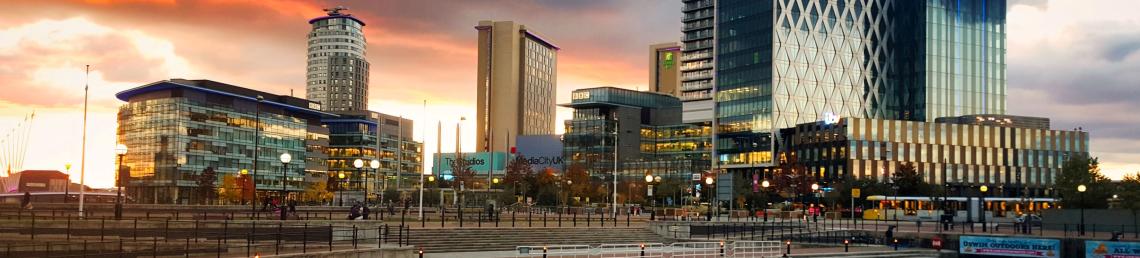Landscape of Salford with an orange sun set in the background