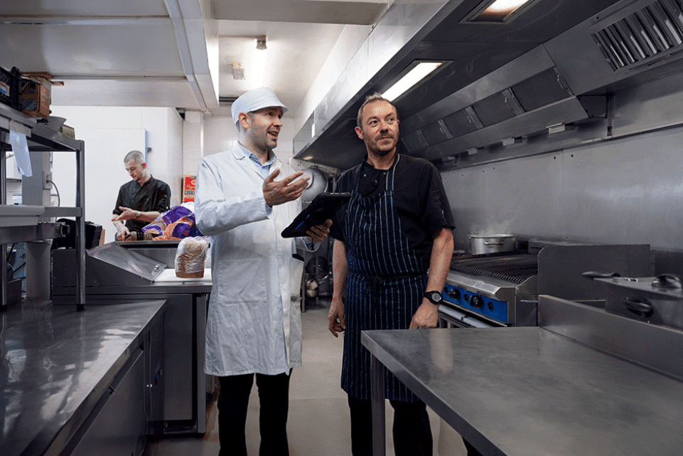 2 male kitchen workers in a industrial kitchen