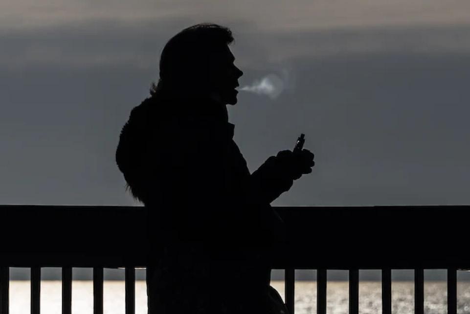Person vaping next to the sea
