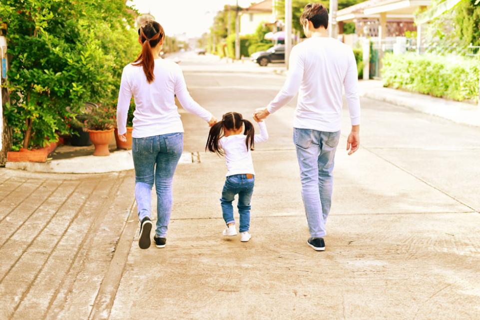 Parents walking down the street with their child