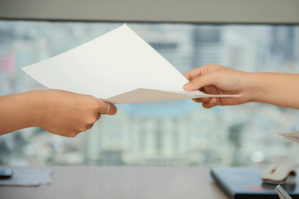 two hands passing a document to each other
