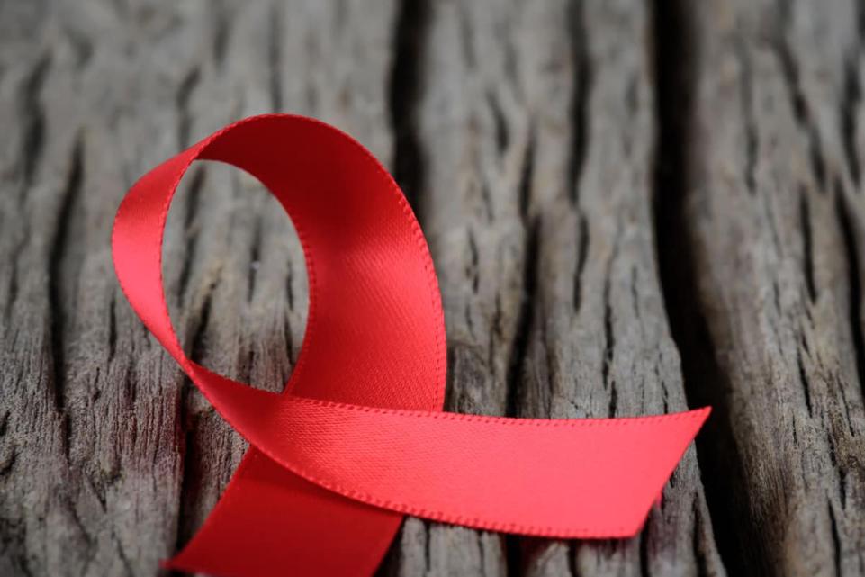 World Aids Day red ribbon in wooden table